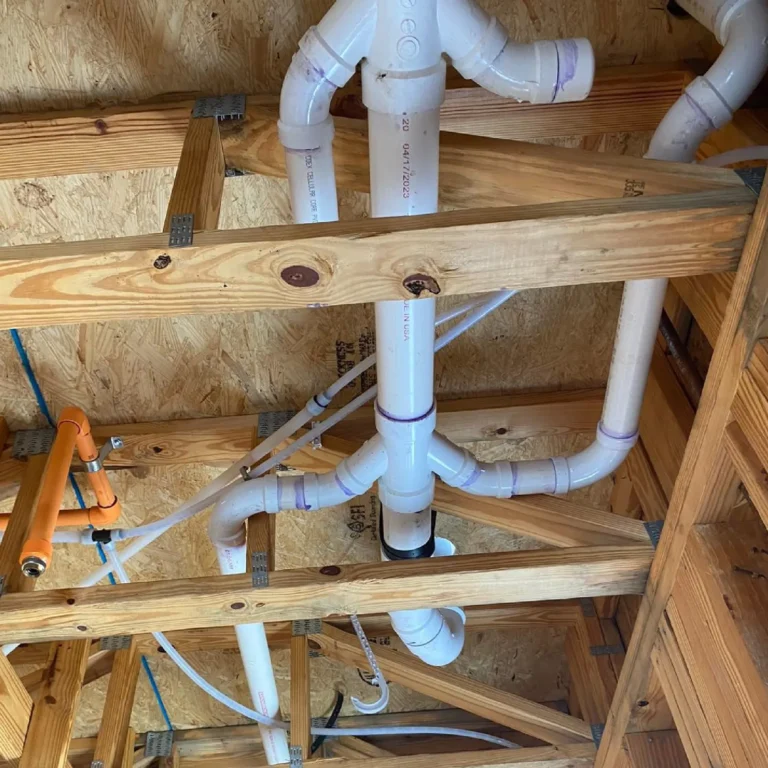 Commercial plumbing rough-in in South Florida: PVC drain and vent lines run through the floor framing before closing.
