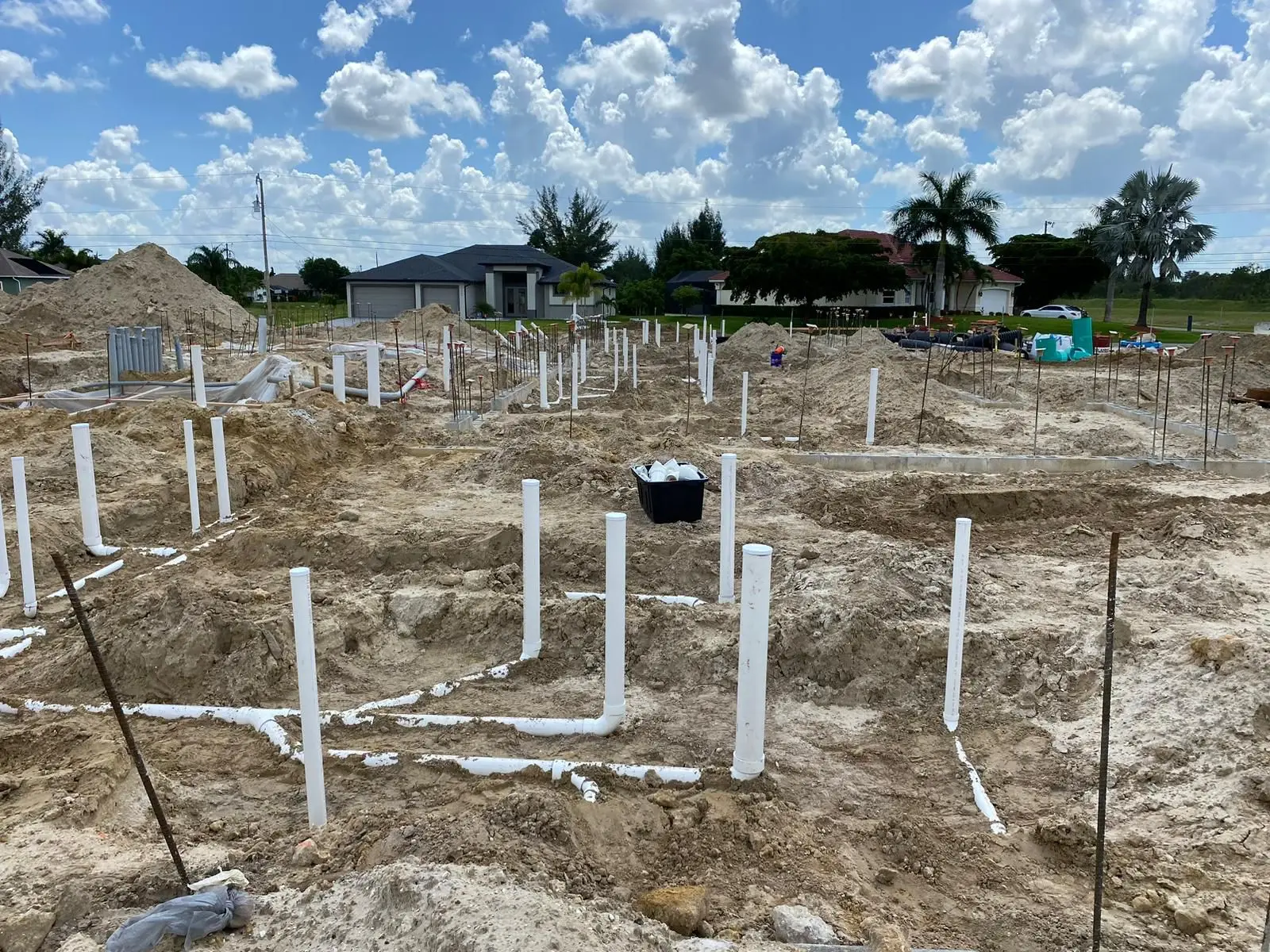 Under-slab plumbing rough-in with PVC stub-ups on a new residential construction site in Florida