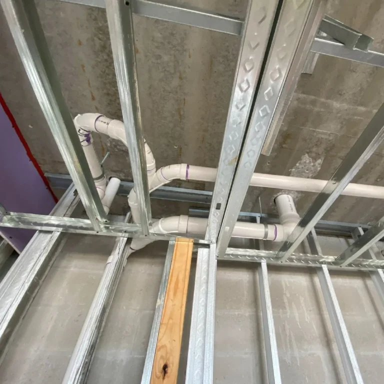 Residential plumbing rough-in in South Florida, with PVC supply and drain lines routed through metal framing.